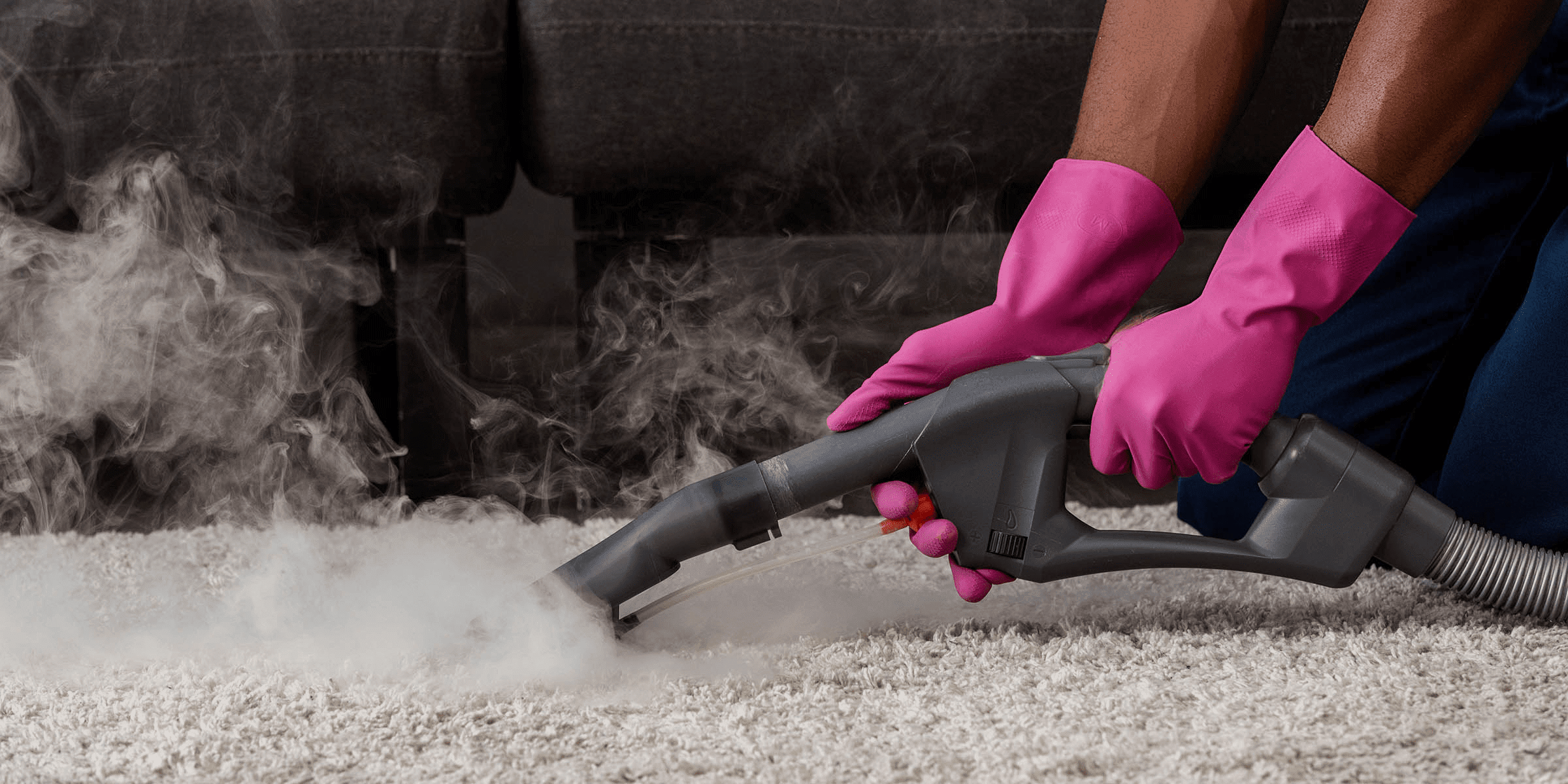 A man cleaning carpet with steam